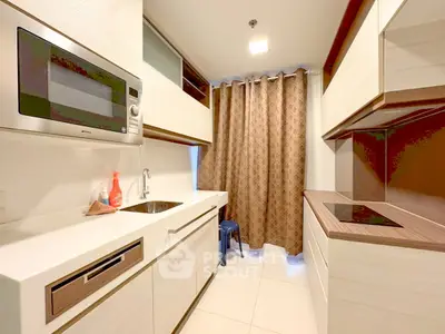 Modern kitchen with sleek cabinetry and built-in appliances in a compact layout.