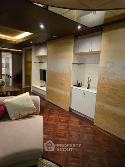 Luxurious living room with elegant wood flooring and stylish built-in shelves, perfect for modern living.