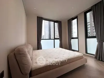 Modern bedroom with large windows and city view, featuring a stylish bed and elegant curtains.