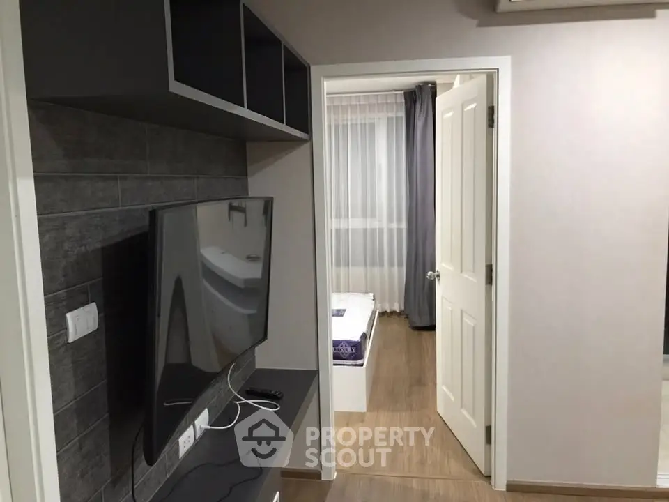 Modern apartment interior with TV and view into bedroom