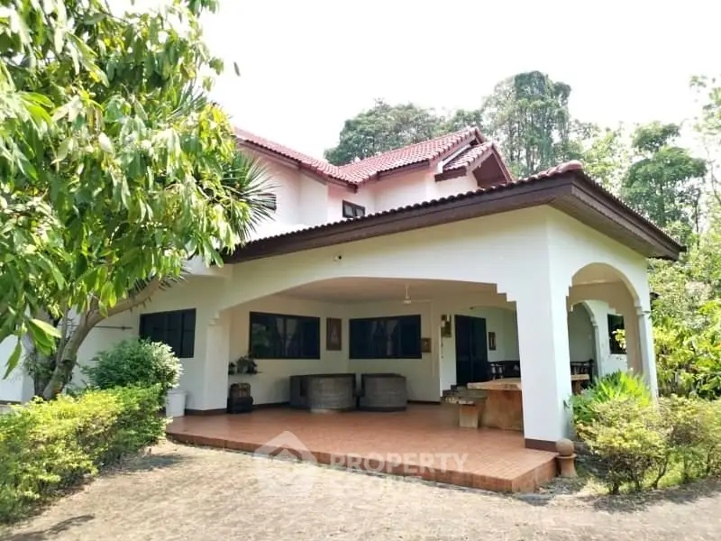 Charming two-story house with spacious patio and lush garden, perfect for family living.