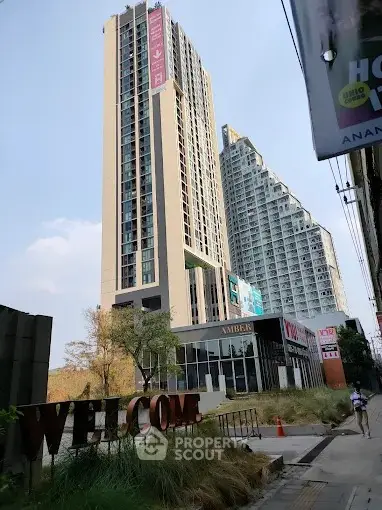 Modern high-rise building with sleek architecture and welcoming entrance in urban setting.