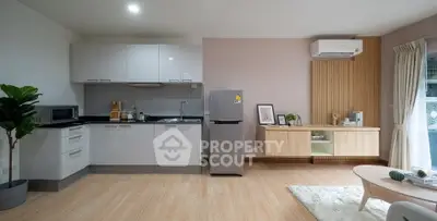 Modern open-layout kitchen and living area with sleek appliances and stylish decor.