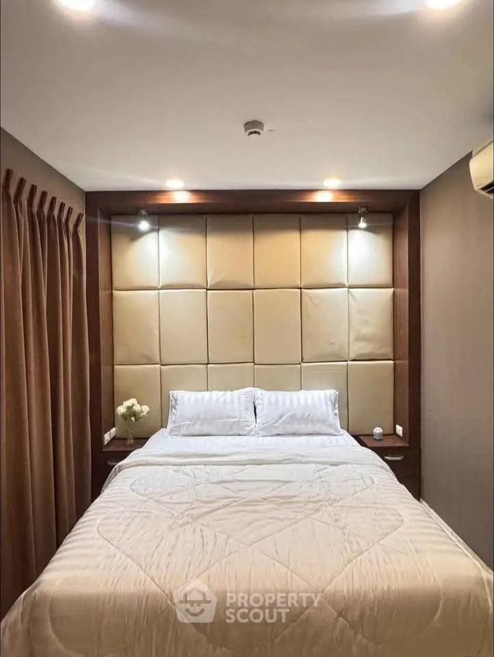 Luxurious bedroom with elegant lighting and plush headboard in modern apartment.