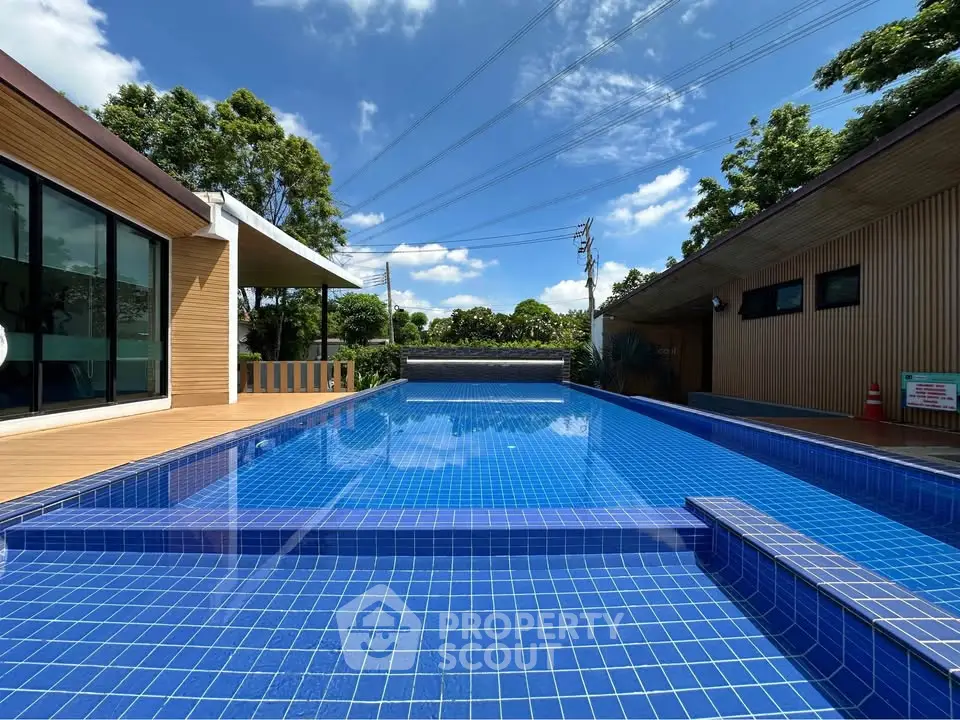 Luxurious outdoor pool with modern design and lush greenery, perfect for relaxation and entertainment.