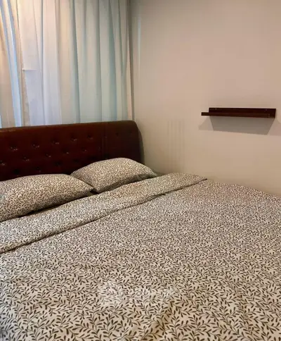 Cozy bedroom with elegant headboard and stylish bedding in modern apartment.