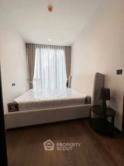 Modern bedroom with large window and city view, featuring a stylish bed and elegant decor.