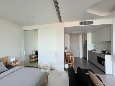 Modern studio apartment with sleek kitchen and cozy bedroom area, perfect for urban living.