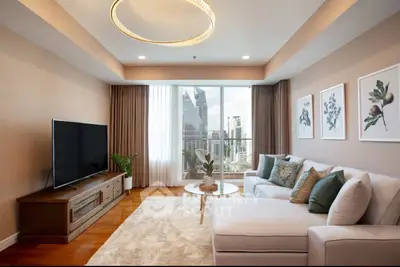 Luxurious living room with modern decor and city view, featuring a large TV and elegant lighting.