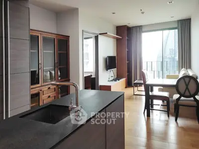 Modern open-layout living room with sleek kitchen and city view balcony, perfect for urban living.