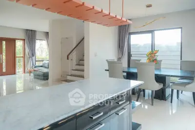 Spacious modern living and dining area with elegant marble countertop and natural light.