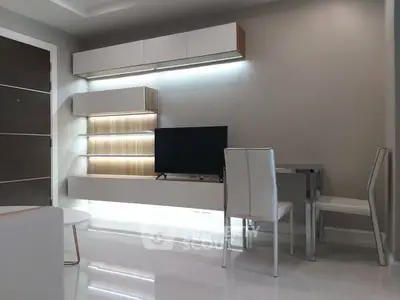 Modern living room with sleek furniture and mounted TV, featuring minimalist design and ambient lighting.