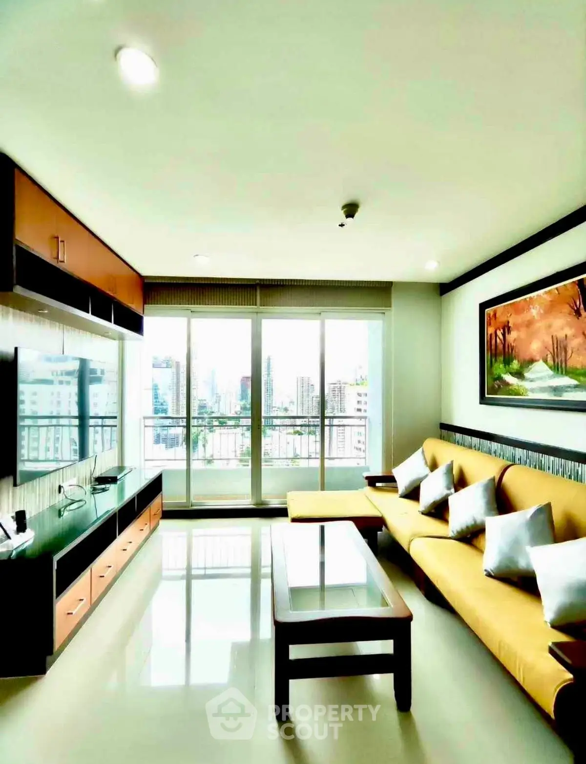 Spacious living room with modern decor and city view, featuring a cozy sofa and entertainment unit.