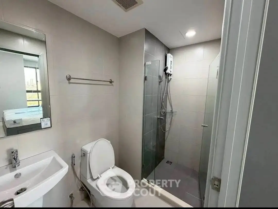 Modern bathroom with glass shower and sleek fixtures in a contemporary apartment.