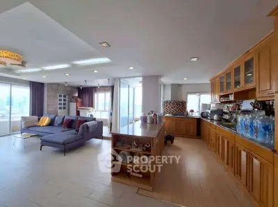 Spacious open-plan living room and kitchen with modern design and city views.