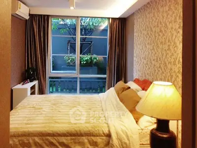Cozy bedroom with elegant decor and large window overlooking a garden view.