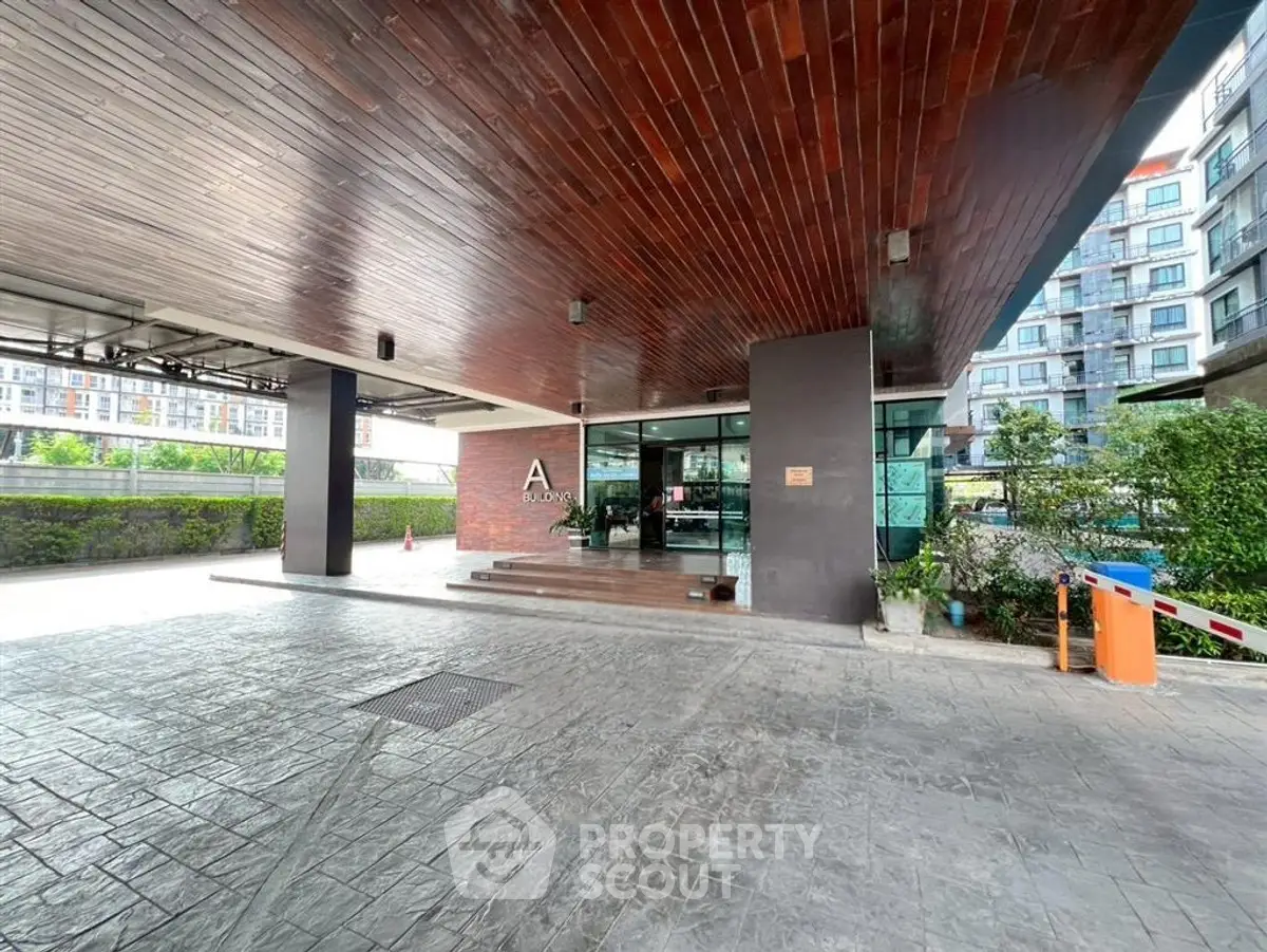 Modern building entrance with sleek design and spacious driveway