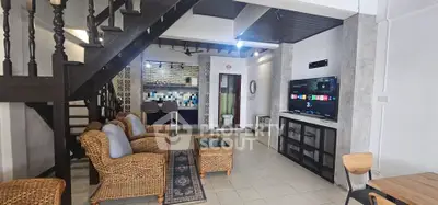 Charming open-layout living room with rustic staircase and modern amenities