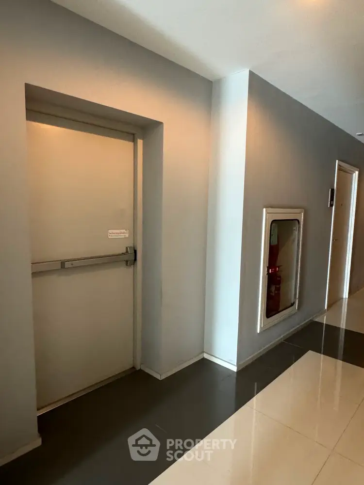 Modern building hallway with emergency exit and fire safety equipment