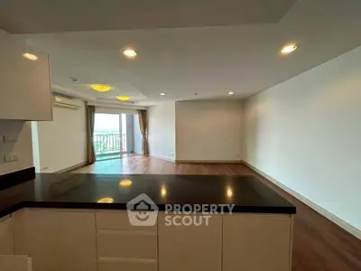 Spacious open-plan living room with balcony and modern kitchen counter