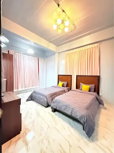 Spacious twin bedroom with elegant lighting and marble flooring, perfect for modern living.