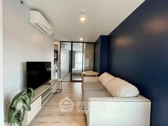 Modern living room with sleek design, featuring a cozy sofa, flat-screen TV, and stylish blue accent wall.