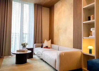 Elegant living room with modern sofa, stylish decor, and large window for natural light.