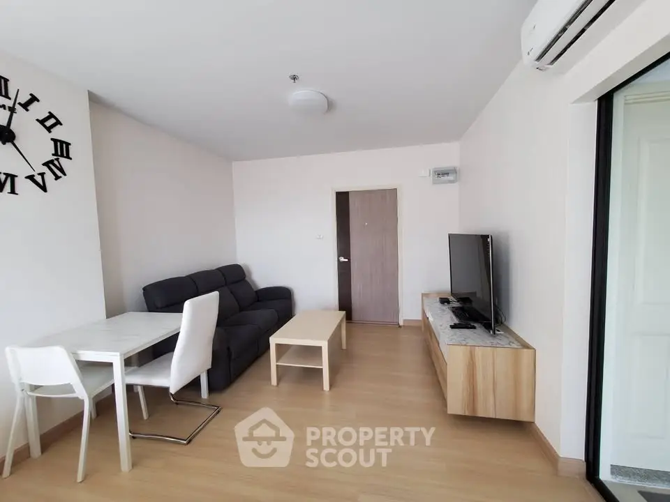Modern living room with sleek furniture and wall clock, featuring a cozy dining area.
