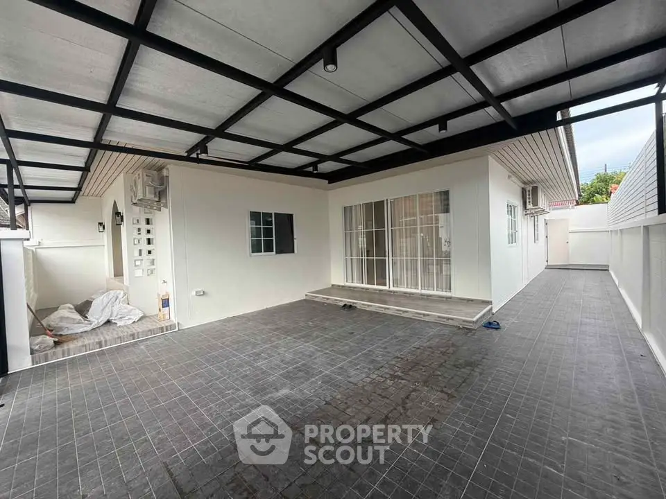 Spacious covered patio with modern design and ample natural light, perfect for outdoor gatherings.