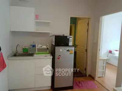Compact kitchen with fridge and sink in modern apartment