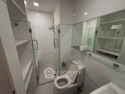 Modern bathroom with glass shower and sleek fixtures in a contemporary apartment.