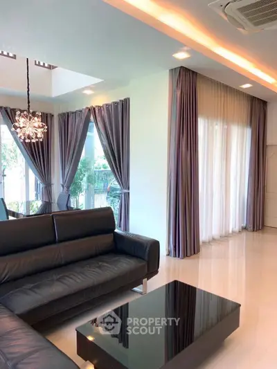 Elegant living room with modern black leather sofa and chic lighting