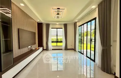 Spacious modern living room with large windows and garden view, perfect for family gatherings.