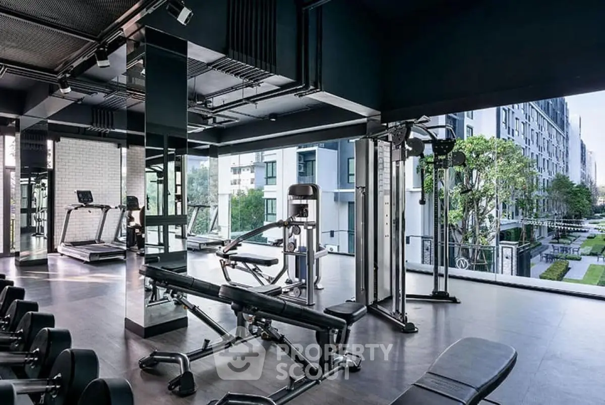 Modern gym with state-of-the-art equipment and panoramic view in luxury apartment complex.