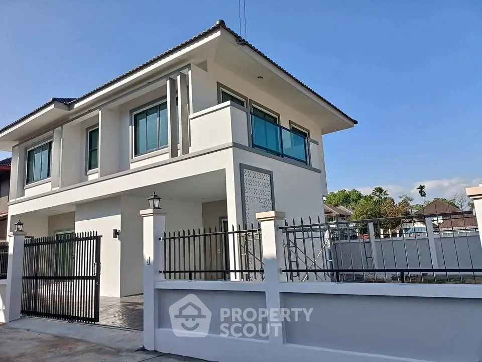 Modern two-story house with sleek design and spacious outdoor area, perfect for family living.