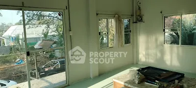 Spacious room with large windows offering natural light and garden view, ideal for customization.