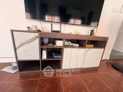 Modern living room with stylish TV stand and marble accents, showcasing contemporary interior design.