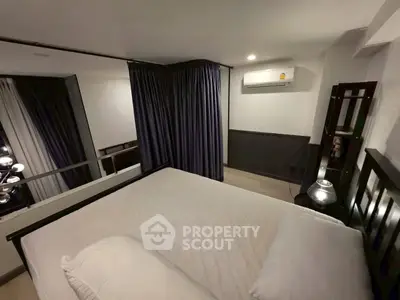 Cozy bedroom with modern air conditioning and elegant curtains, perfect for a restful retreat.