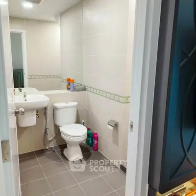 Modern bathroom with sleek fixtures and tiled walls, perfect for a contemporary home.