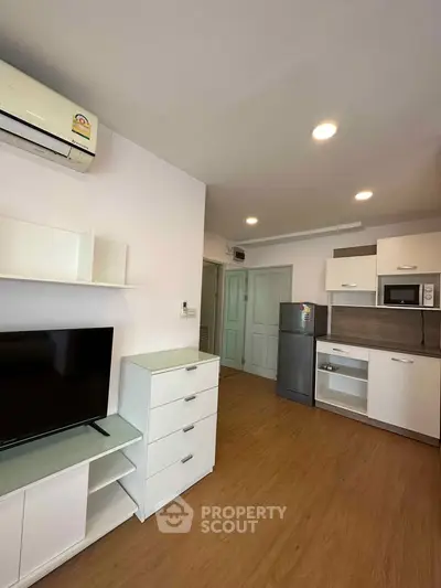 Modern living room with sleek furniture and built-in kitchen appliances