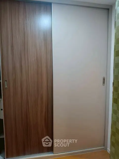 Modern sliding closet doors with wood and white panels in a stylish interior.