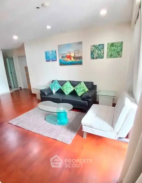 Spacious living room with modern decor and hardwood floors in a stylish apartment.