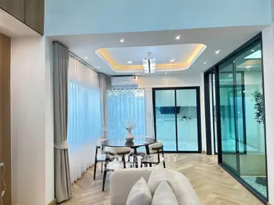 Elegant modern living room with dining area and large windows in a stylish apartment.