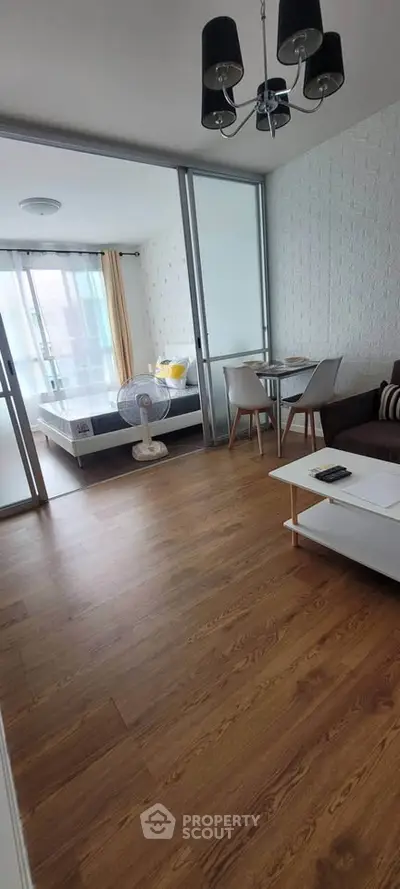 Modern studio apartment with wooden flooring and stylish decor, featuring a cozy living area and bedroom.