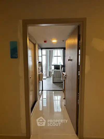 Inviting entrance to a modern apartment with a glimpse of a cozy living room and natural light.