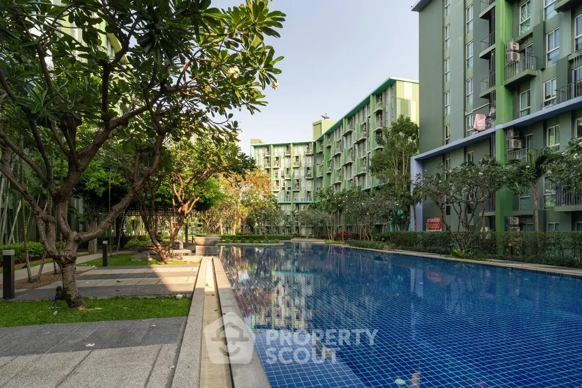 Modern apartment complex with lush garden and inviting swimming pool