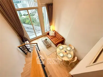 Modern loft apartment with high ceilings and large windows offering a stunning city view.