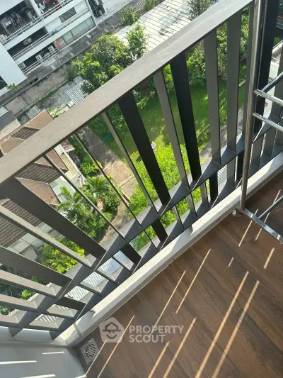 Charming balcony with wooden flooring and lush green view, perfect for relaxation and enjoying nature.
