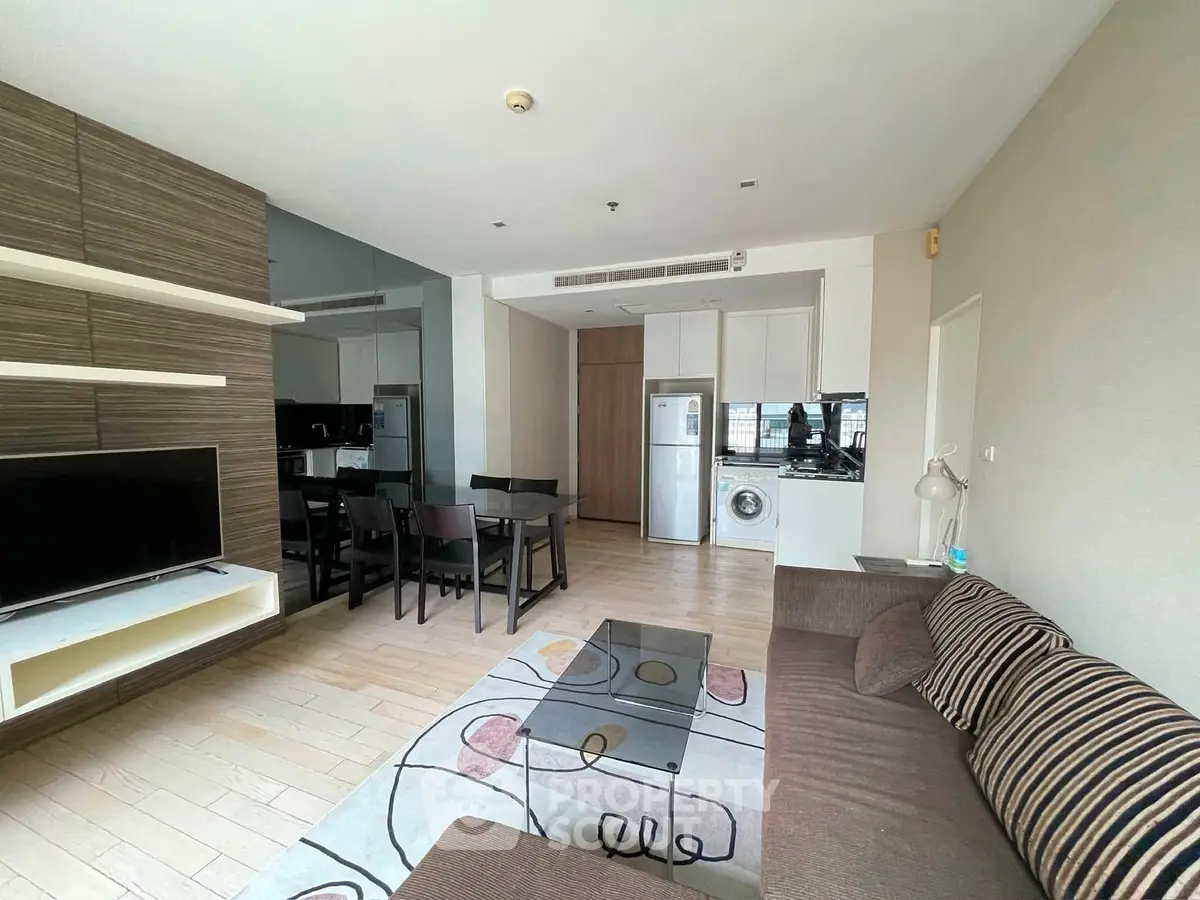 Modern living room with open kitchen and stylish decor in a contemporary apartment.