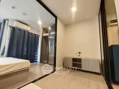 Modern bedroom with mirrored closet and sleek furniture in a stylish apartment.